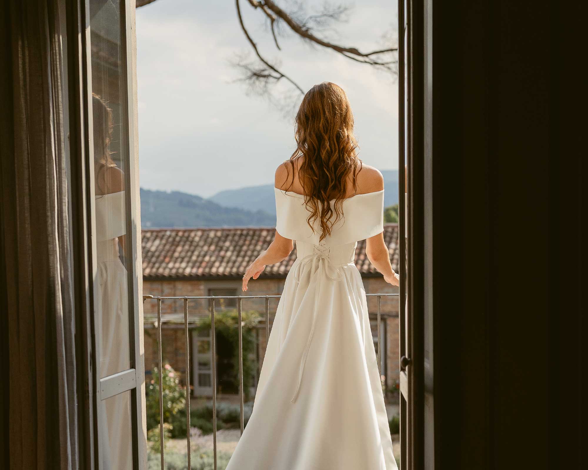vigne di fagnano sposa con strascico affacciata alla finestra con panorama langhe patrimonio unesco